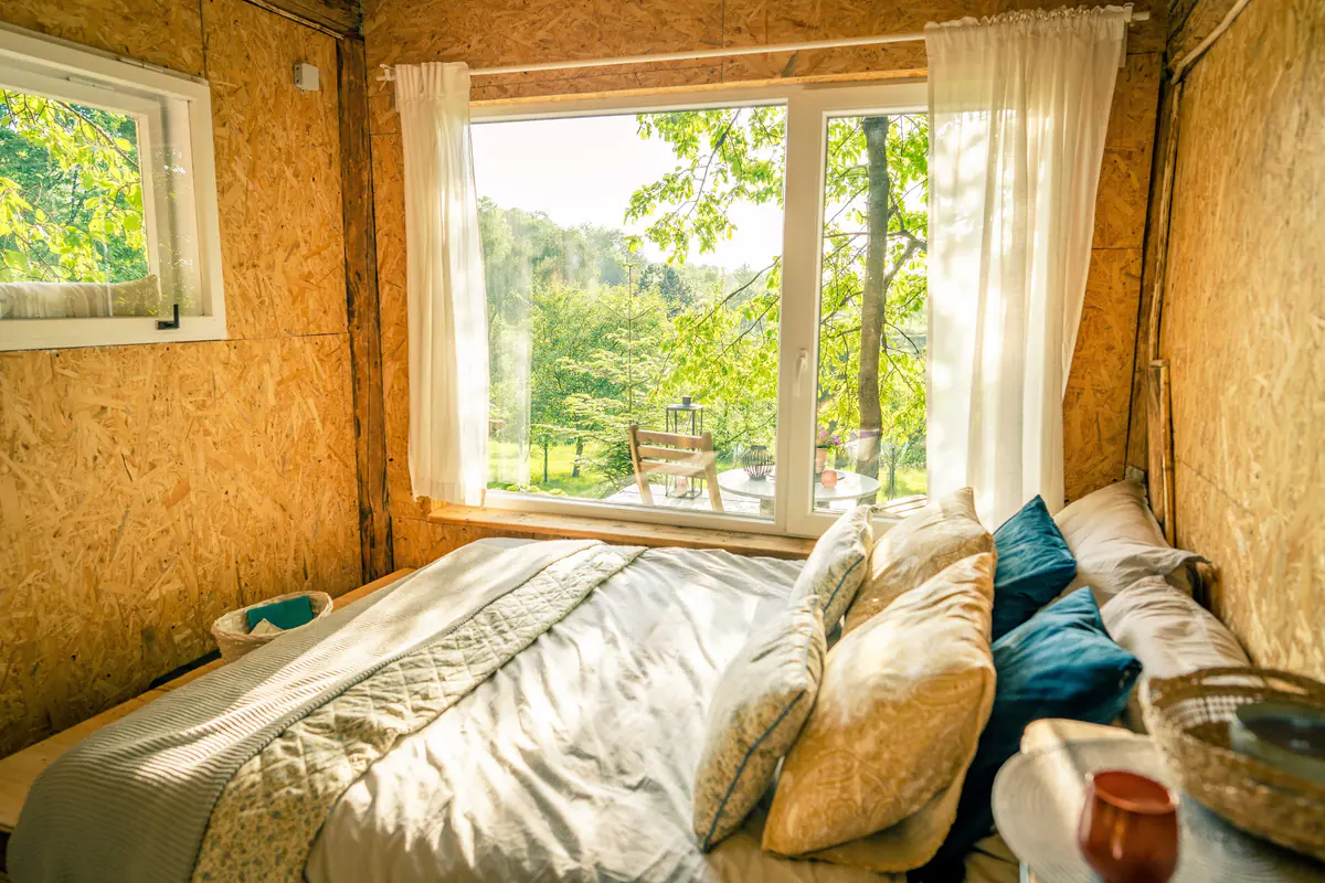 Bed by the window looking out on green
