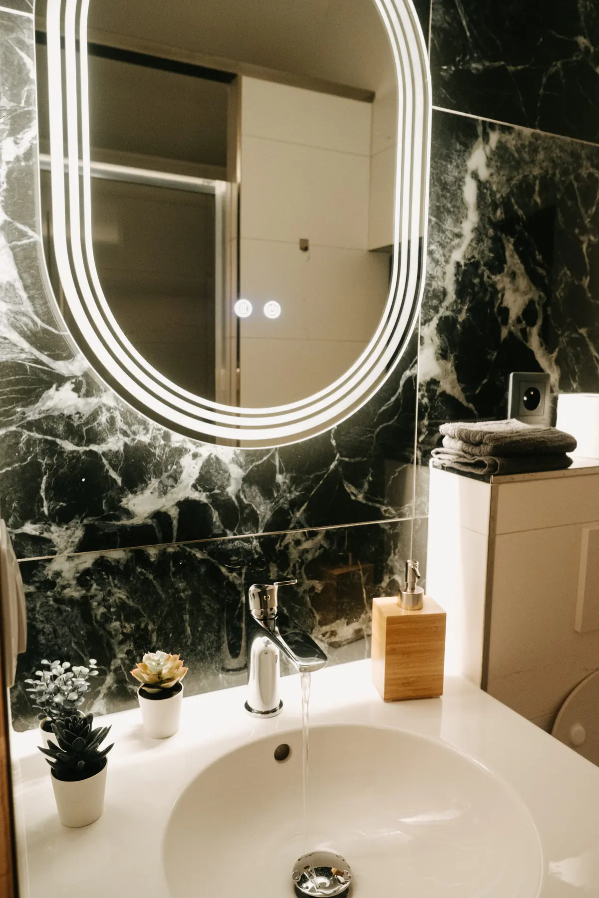 Bathroom with marble and a round mirror