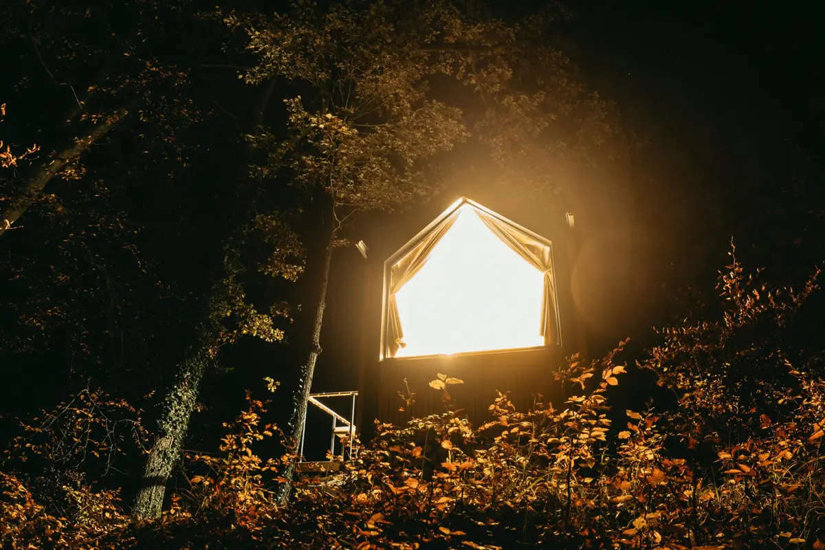 Glamping glowing in an autumn forest at dusk